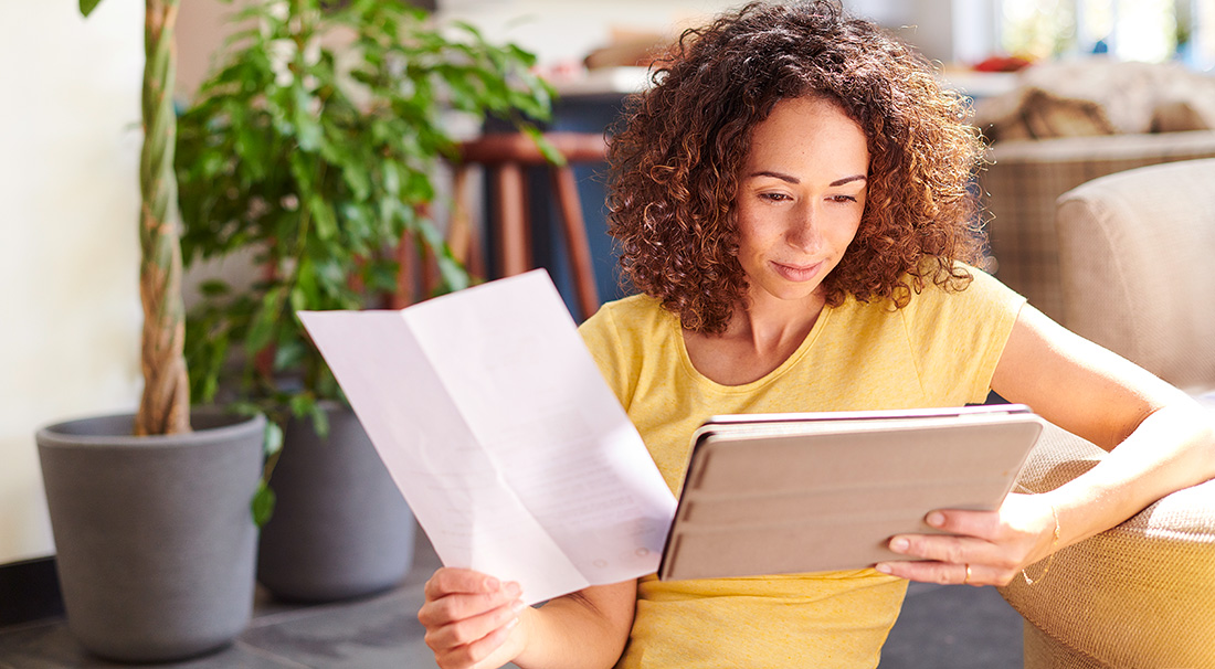 Vrouw kijkt naar een rekening en haar tablet