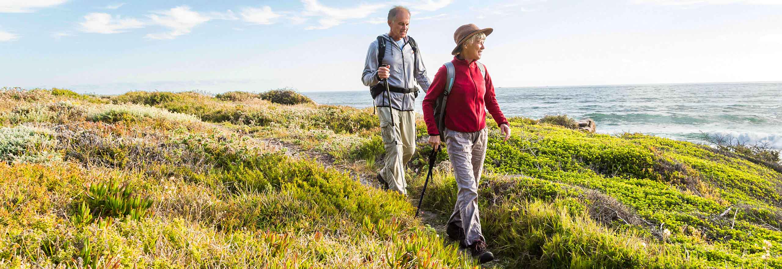 Man en vrouw wandelend aan de kust